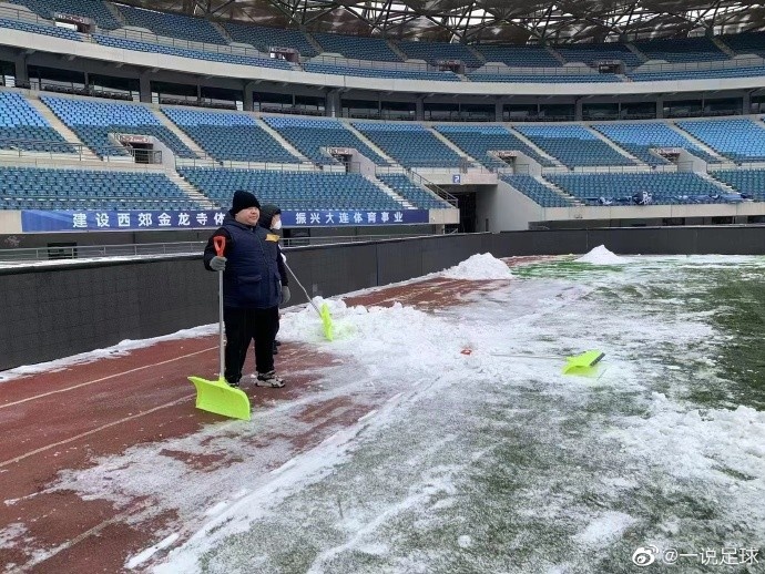 大连体育中心工作人员正努力铲雪，保障今天下午比赛如期进行