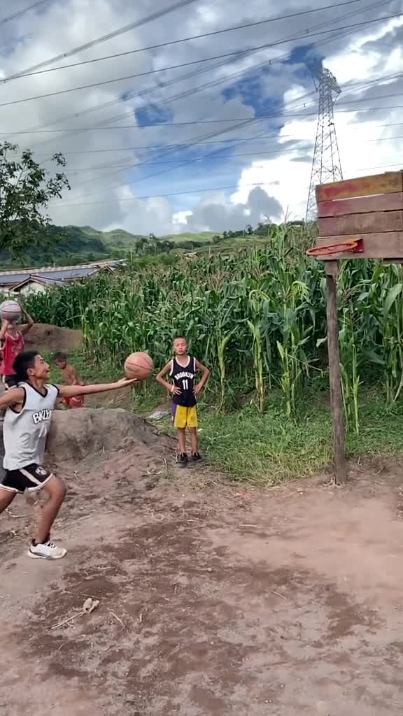 凉山山区里的小孩子 在 玉米地旁立起一个篮筐玩篮球