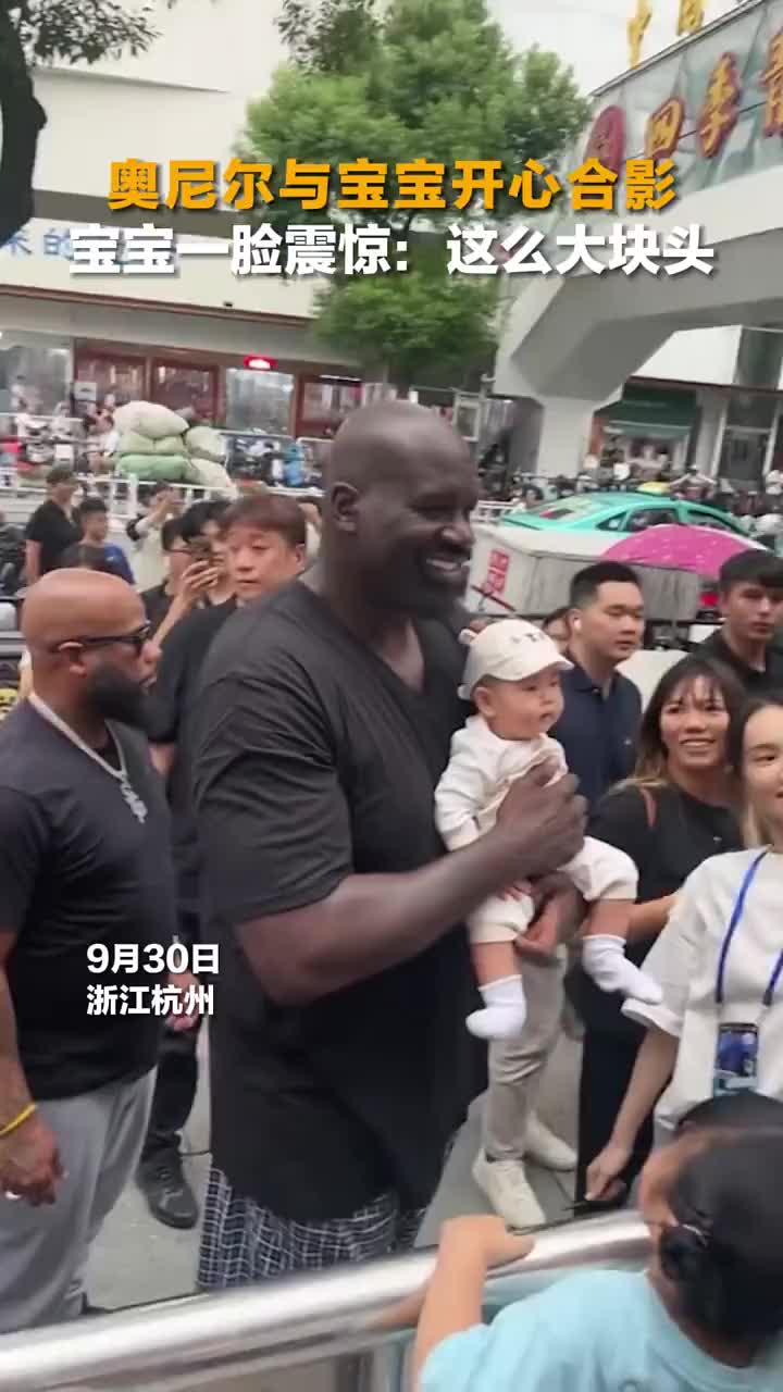 奥尼尔曾在街头与球迷合影 大块头惊呆小宝宝