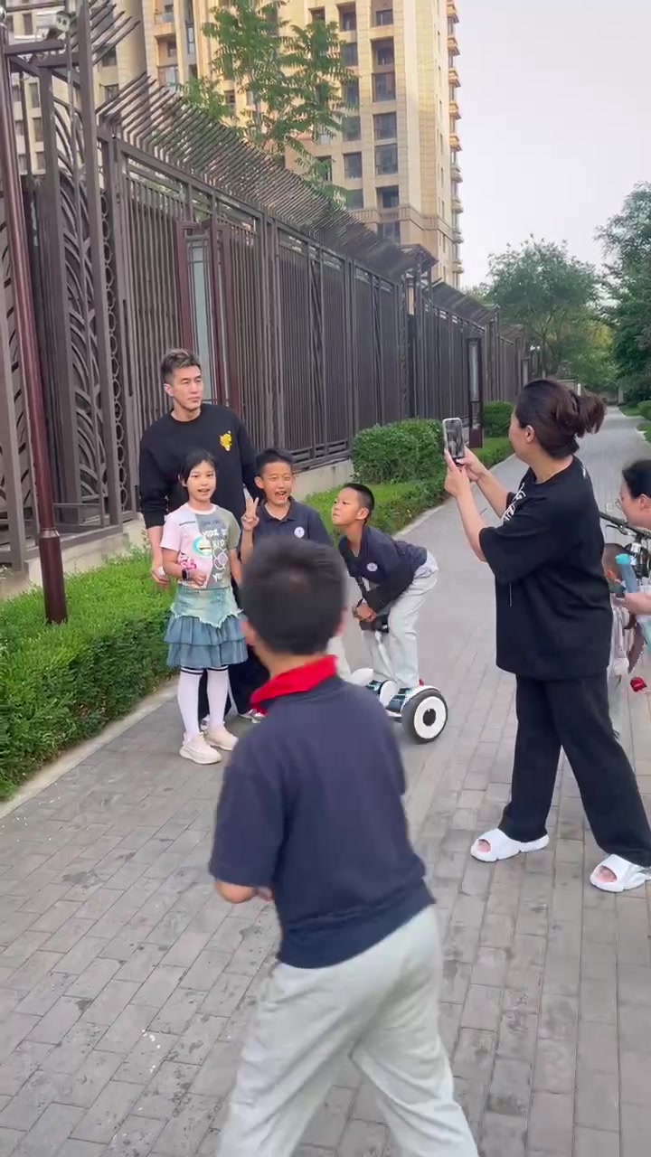 妥妥的孩子王嘛～！郭艾伦在大韩家的小区和几位小孩合影