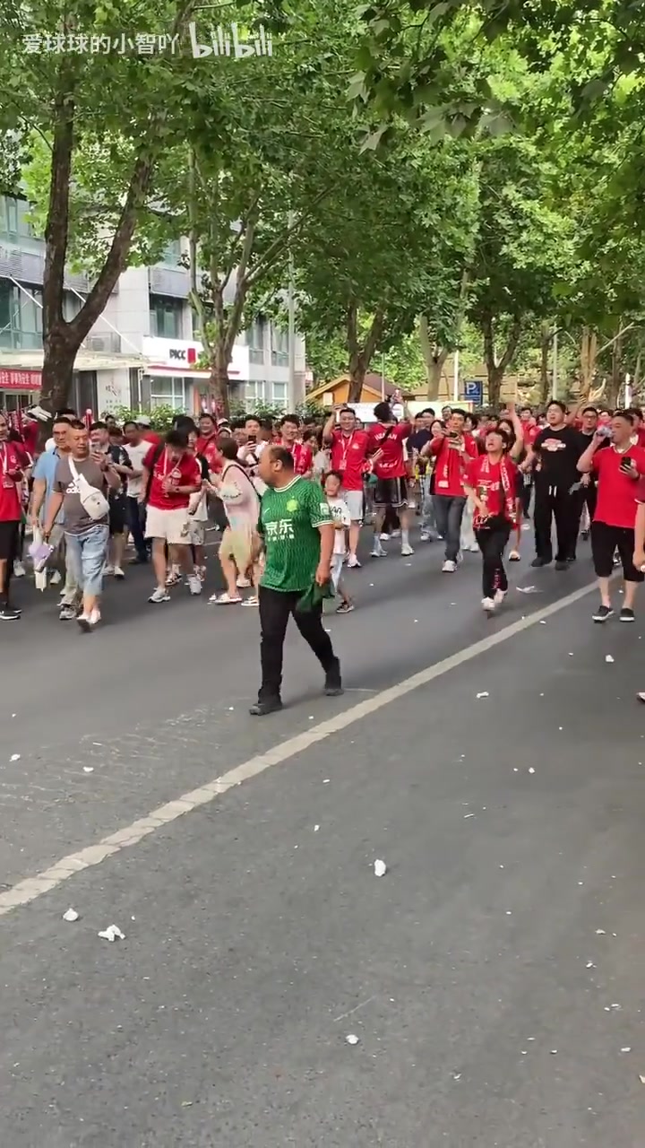 好淡定！一名国安球迷在万人包夹下摇着扇子从容走过！